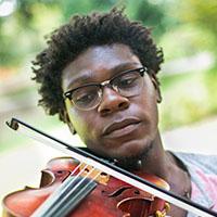 Elijah Carter plays violin in front of MUC